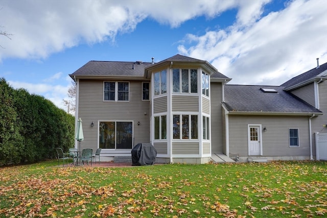 rear view of property featuring a patio and a lawn