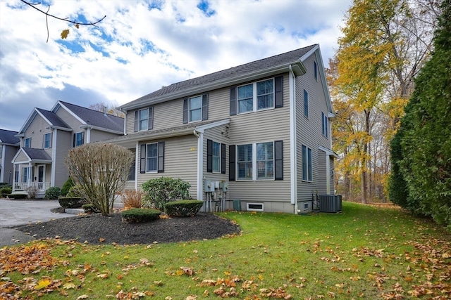 view of front of property with a front lawn and central AC unit