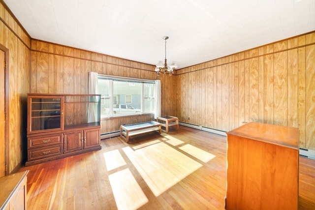 interior space featuring hardwood / wood-style flooring, wooden walls, baseboard heating, and a notable chandelier