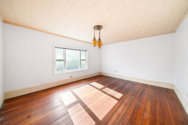 unfurnished room featuring dark wood-type flooring and ornamental molding