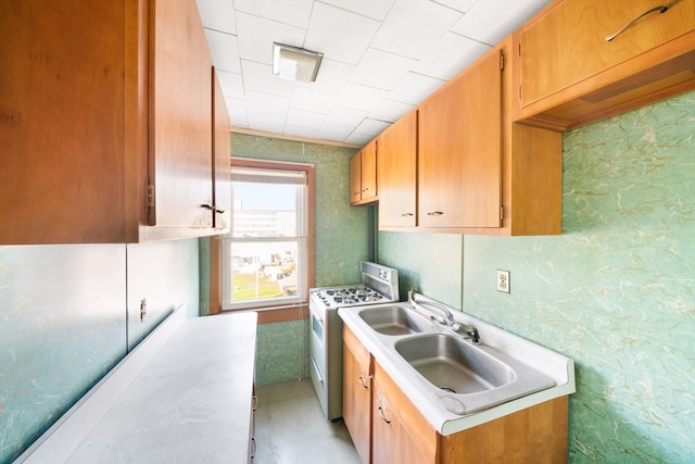 kitchen featuring white range with gas stovetop and sink