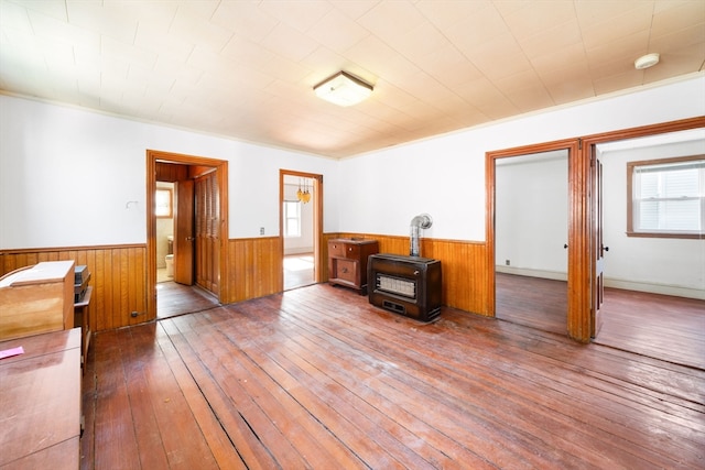 empty room with a wealth of natural light, wooden walls, hardwood / wood-style flooring, and crown molding