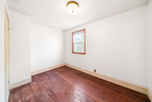 empty room featuring crown molding and dark hardwood / wood-style flooring