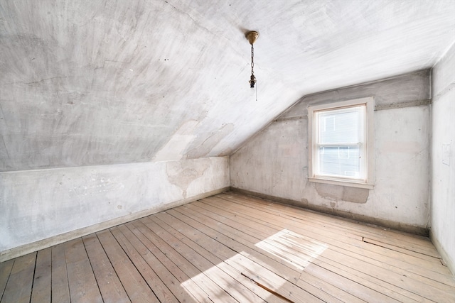 bonus room with light hardwood / wood-style flooring and vaulted ceiling