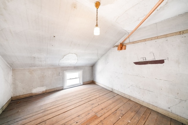 additional living space featuring lofted ceiling and wood-type flooring