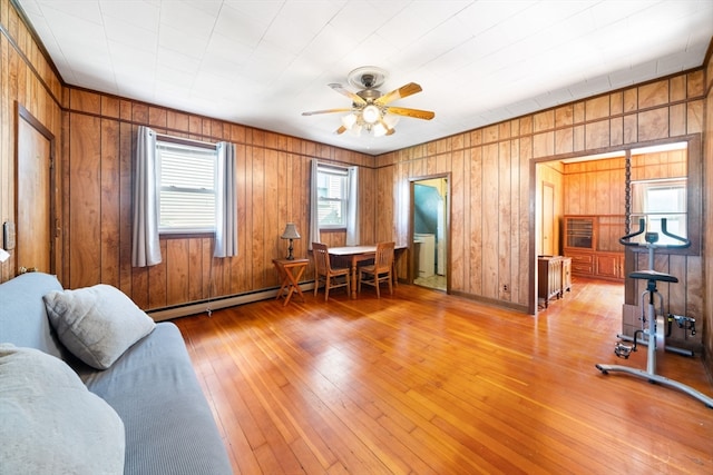 interior space featuring light wood-type flooring, wooden walls, and ceiling fan