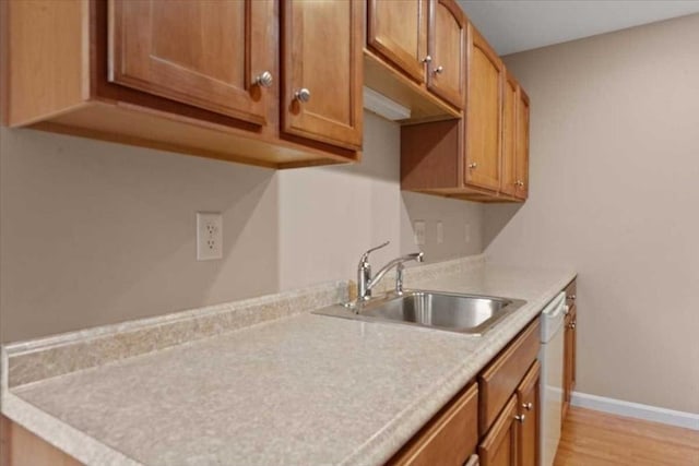 42 Phillips Rd Unit 1, Holden, MA 01520 - kitchen featuring a sink, light countertops, baseboards, light wood-style flooring, and brown cabinetry