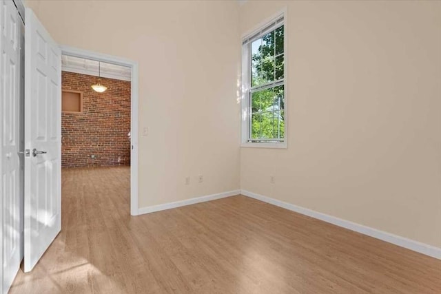 42 Phillips Rd Unit 1, Holden, MA 01520 - empty room with brick wall, light wood-style flooring, and baseboards