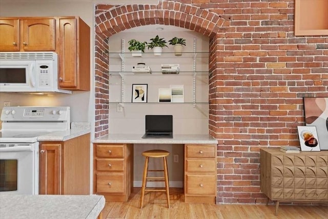 42 Phillips Rd Unit 1, Holden, MA 01520 - kitchen with white appliances, light wood-style floors, light countertops, brown cabinets, and brick wall
