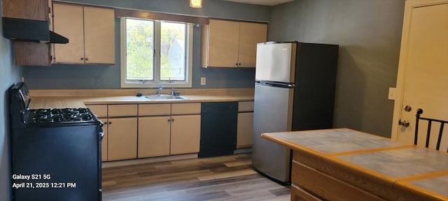 50 Clark St Unit 12, Fall River, MA 02720 - kitchen with light wood-style flooring, a sink, black appliances, light countertops, and cream cabinets