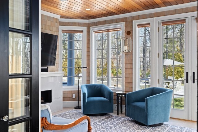 sunroom with a healthy amount of sunlight, a fireplace, and wooden ceiling