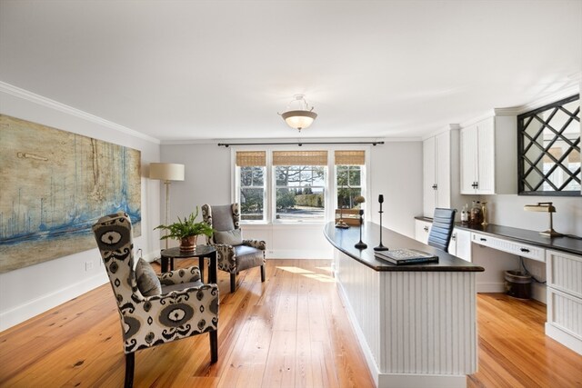 kitchen featuring a center island, white cabinetry, crown molding, and light hardwood / wood-style flooring