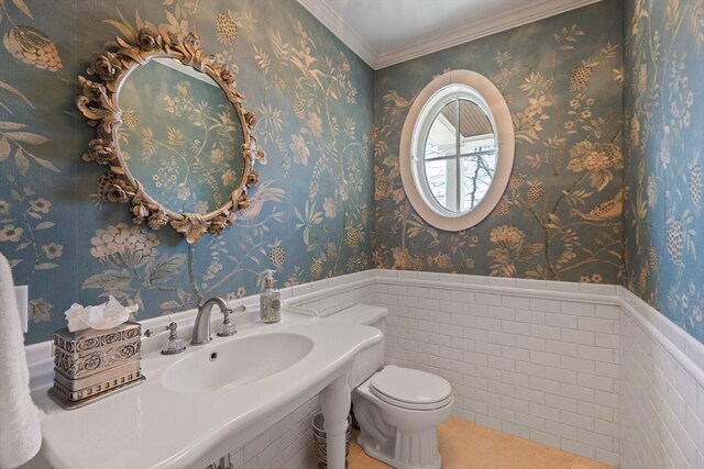 bathroom with tile walls, toilet, tile floors, and sink