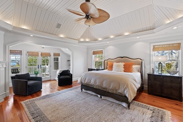 bedroom featuring hardwood / wood-style floors, ceiling fan, a raised ceiling, access to outside, and french doors