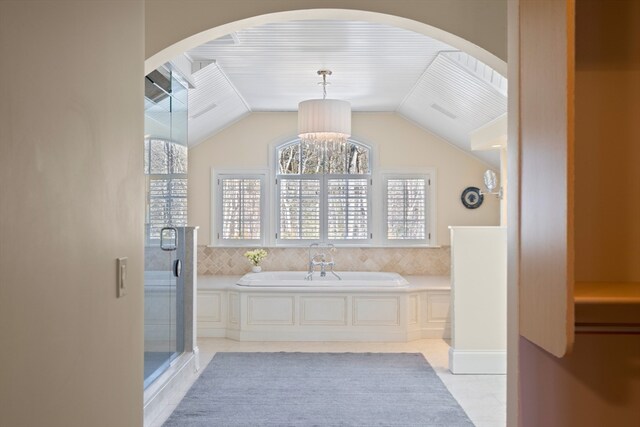 bathroom featuring an inviting chandelier, tile floors, independent shower and bath, and vaulted ceiling