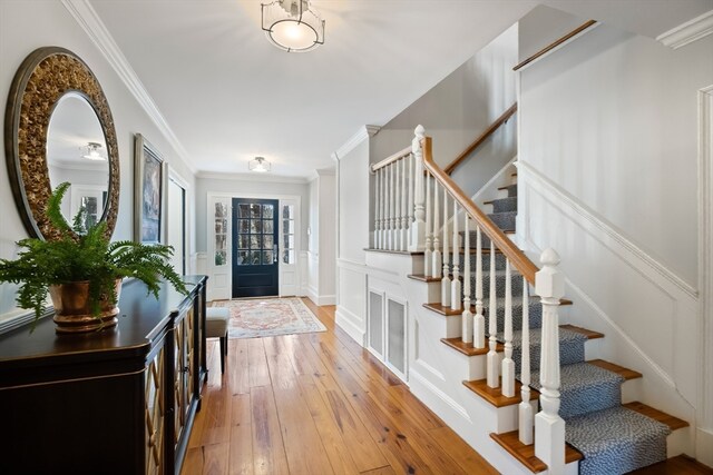 foyer with crown molding and light wood-type flooring