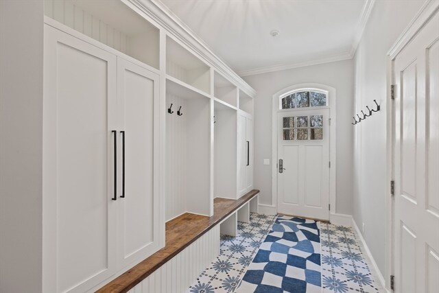 mudroom with crown molding and light tile flooring