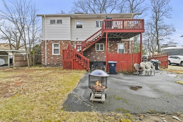 10 Gleason Rd, Shrewsbury, MA 01545 - back of property with stairway, a fire pit, brick siding, and a wooden deck