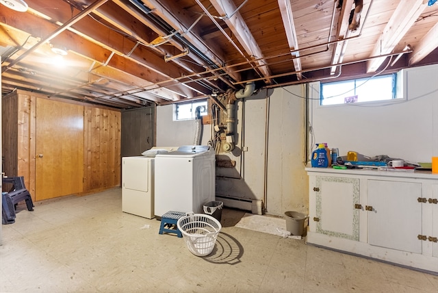 below grade area featuring light floors, baseboard heating, and independent washer and dryer