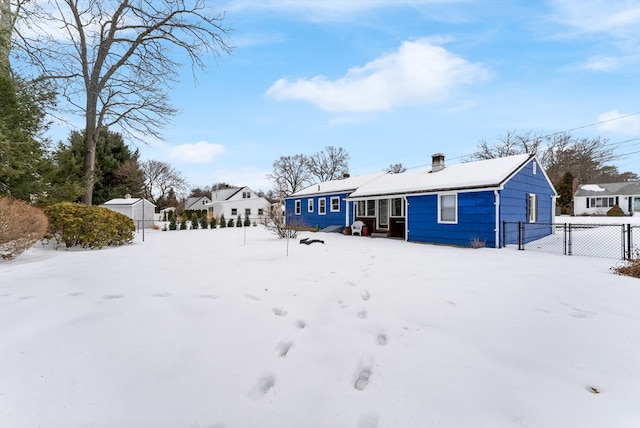 snow covered back of property with fence