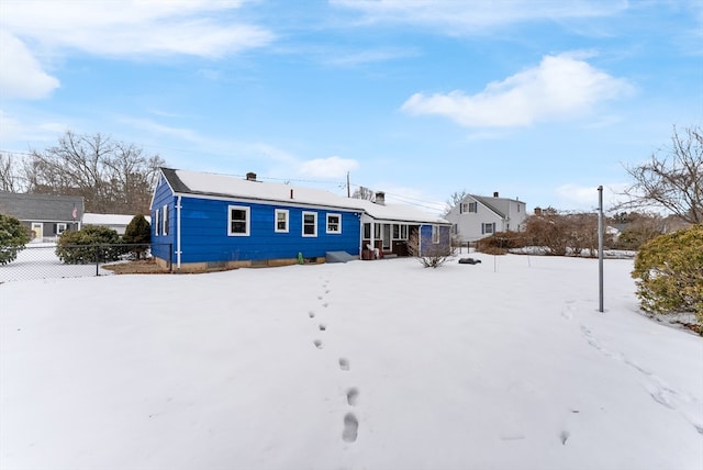 snow covered house with fence