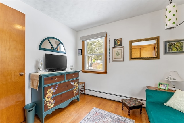 sitting room featuring baseboard heating and light wood-type flooring