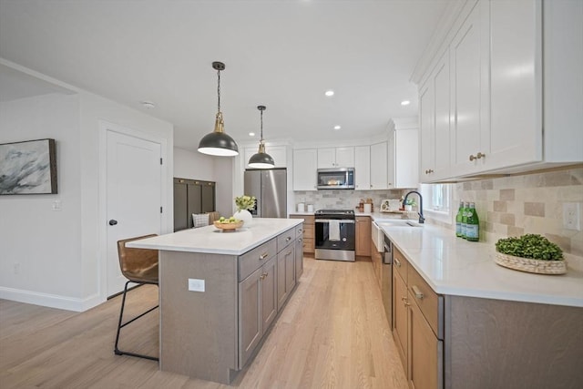 13 Nantucket Dr, Mattapoisett, MA 02719 - kitchen with stainless steel appliances, light wood-style flooring, a breakfast bar, tasteful backsplash, and recessed lighting