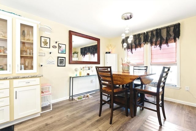 dining room featuring light wood-style flooring and baseboards