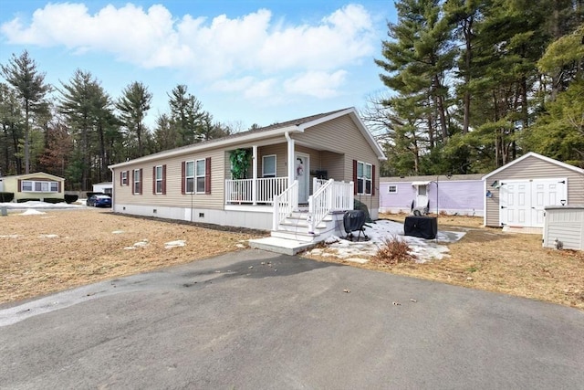 manufactured / mobile home with a storage unit, crawl space, a porch, and an outdoor structure