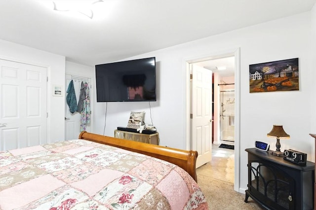 bedroom featuring light carpet, ensuite bathroom, and a closet