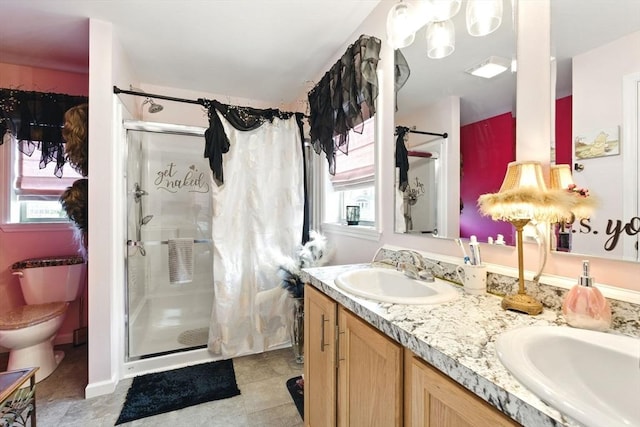 full bath with a sink, plenty of natural light, double vanity, and a shower stall