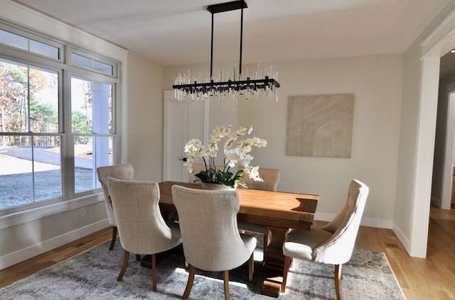 dining space with light hardwood / wood-style flooring and a chandelier