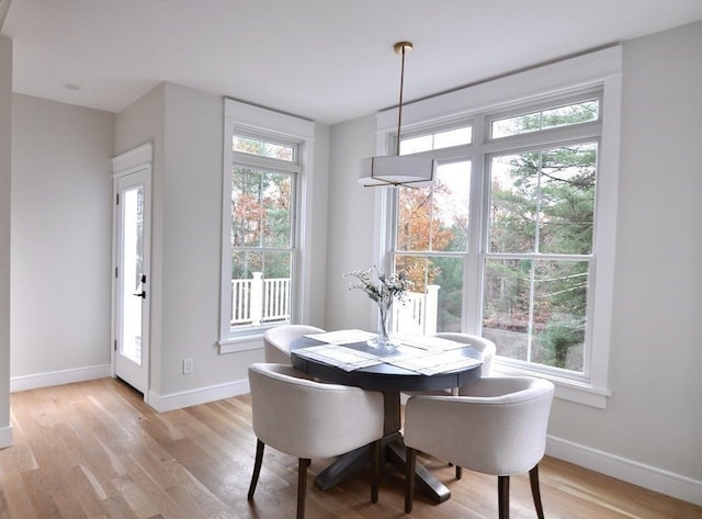 dining space with light wood-type flooring and a healthy amount of sunlight