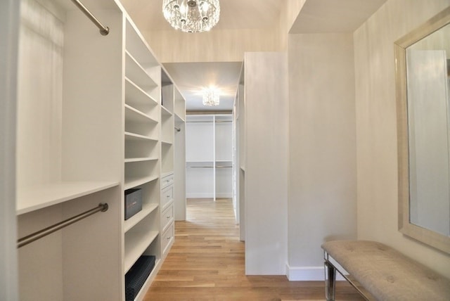 spacious closet featuring light wood-type flooring and a chandelier