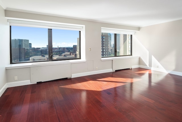 unfurnished room with ornamental molding and hardwood / wood-style flooring