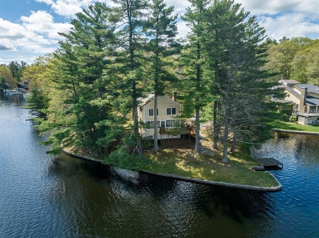 view of subject property featuring a nearby body of water and a forest