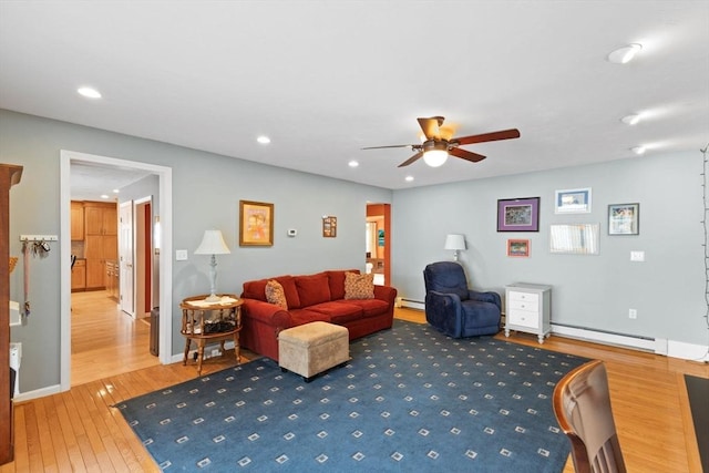 living room with hardwood / wood-style floors, ceiling fan, and baseboard heating