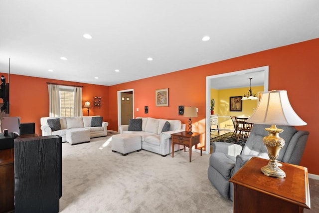 carpeted living room with an inviting chandelier