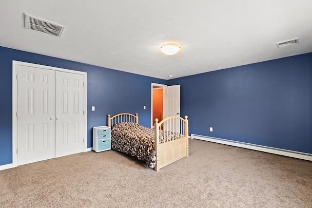 bedroom with a closet, baseboard heating, and carpet flooring