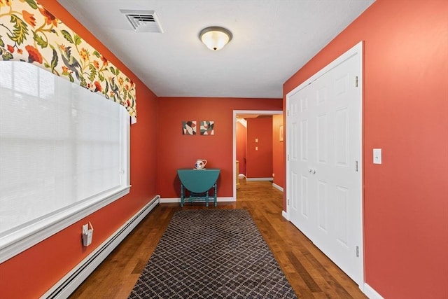 hallway with dark wood-type flooring and baseboard heating