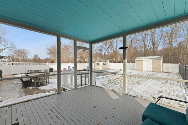 snow covered deck with a shed