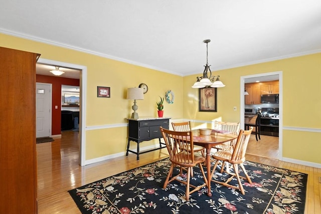 dining area featuring ornamental molding and light wood-type flooring