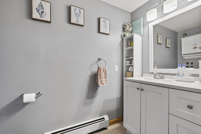 bathroom with vanity, a baseboard heating unit, and baseboards