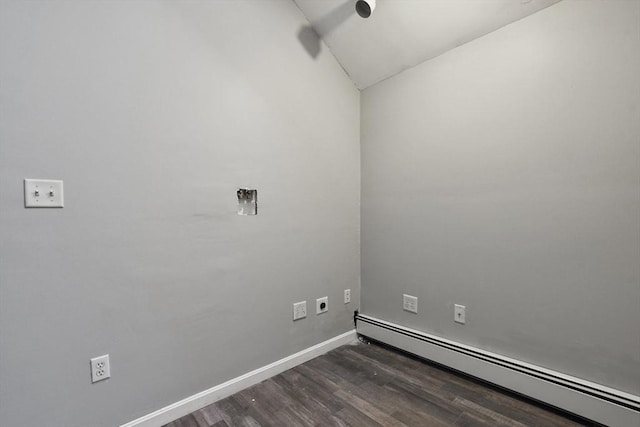 unfurnished room with dark wood finished floors, a baseboard heating unit, and baseboards