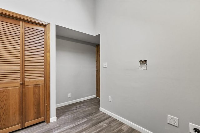 unfurnished bedroom with dark wood-type flooring, baseboards, and a closet