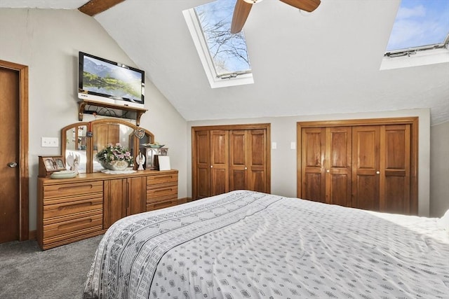 bedroom with lofted ceiling with skylight, multiple closets, carpet floors, and ceiling fan