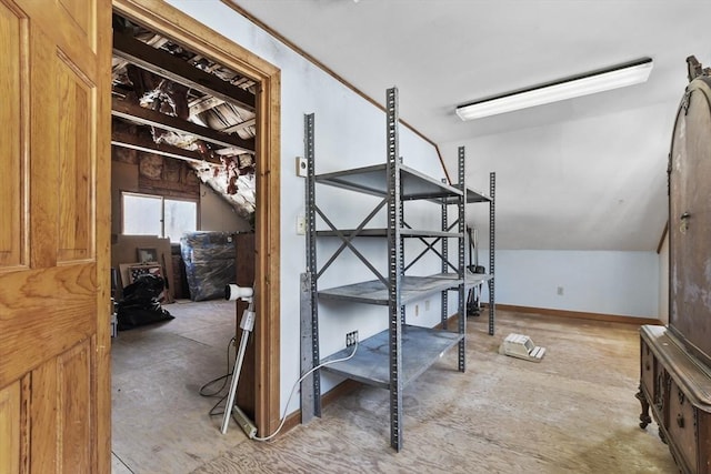 interior space featuring baseboards and lofted ceiling