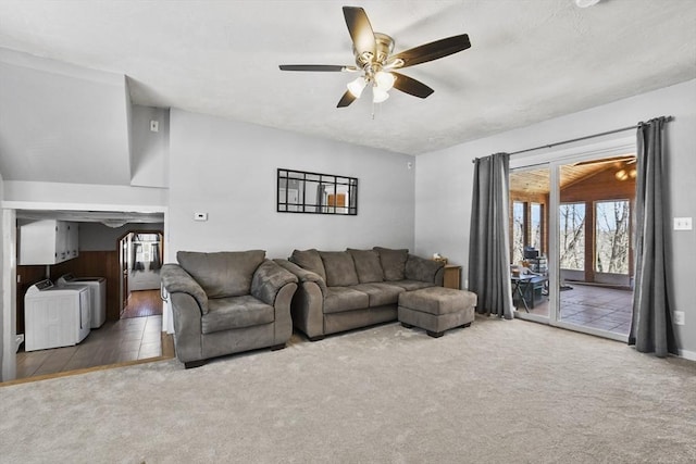 living area with washer and dryer, ceiling fan, carpet flooring, and vaulted ceiling