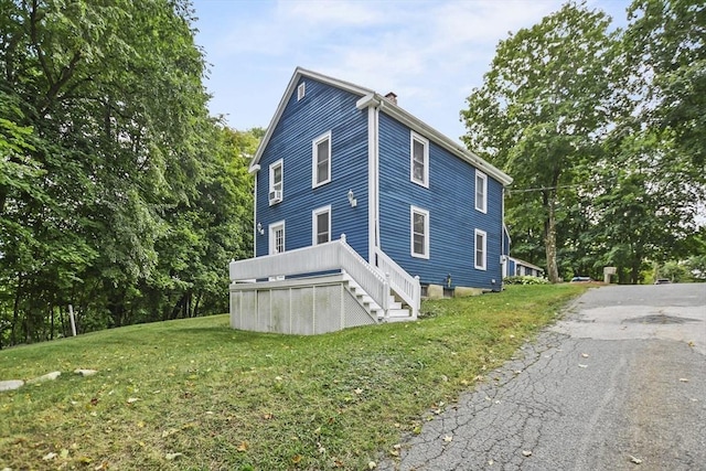 view of property exterior featuring a yard and a chimney