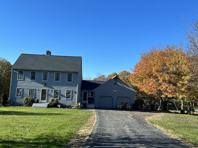 33 Whittemore St, Leicester, MA 01524 - colonial house featuring a chimney, asphalt driveway, an attached garage, and a front lawn